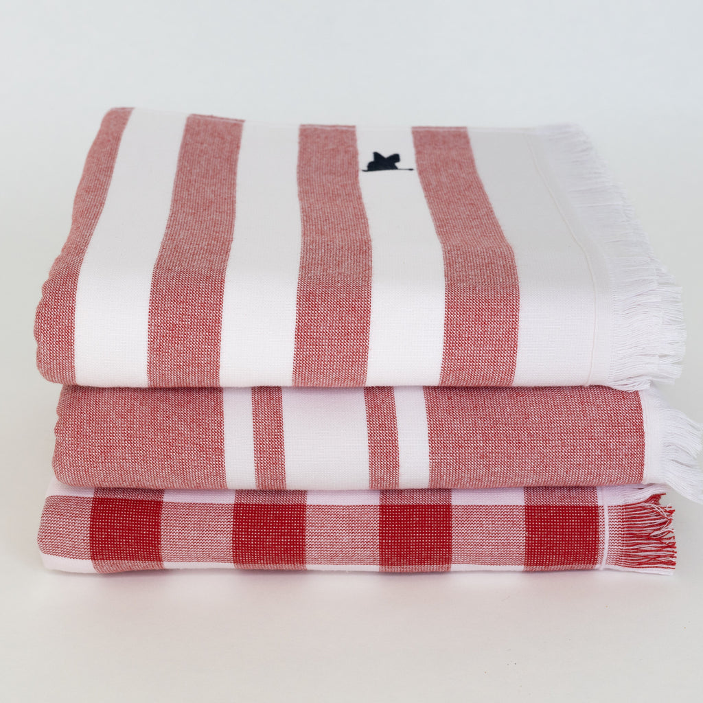 Stack of red and white striped and gingham beach Turkish towels 