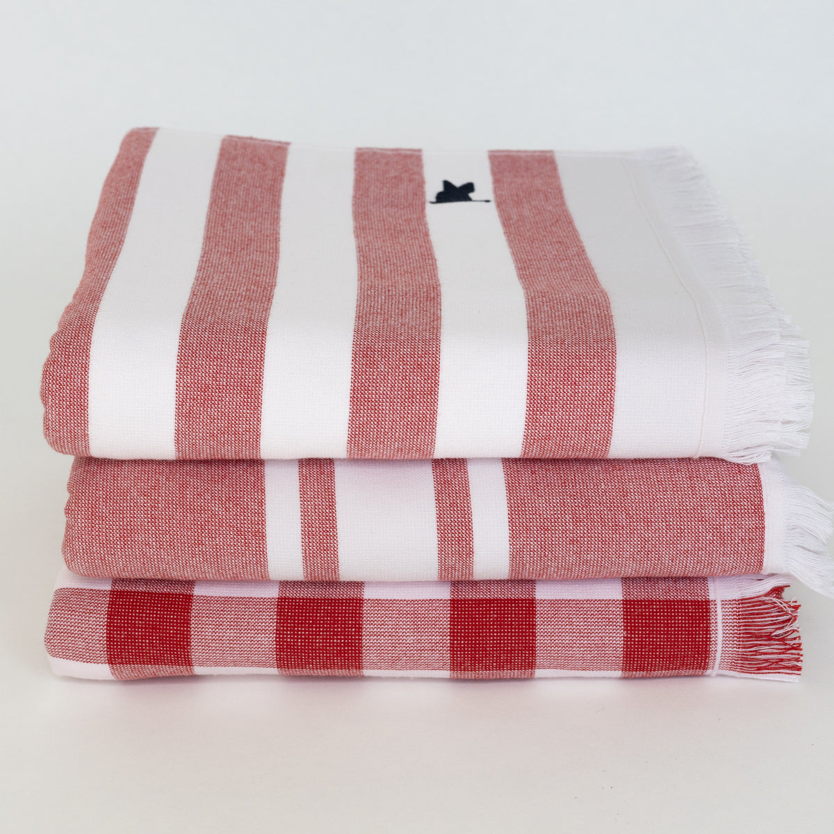 Stack of red and white striped and gingham beach Turkish towels 