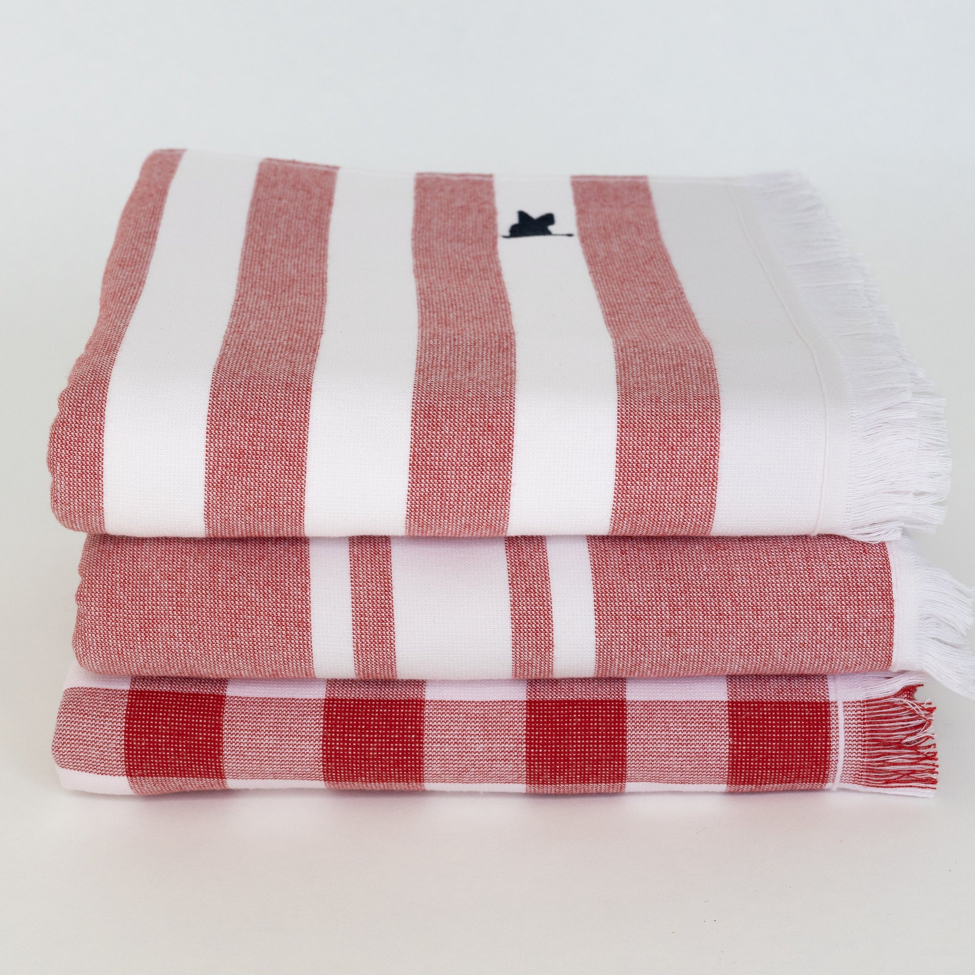 Stack of red and white striped and gingham beach Turkish towels 