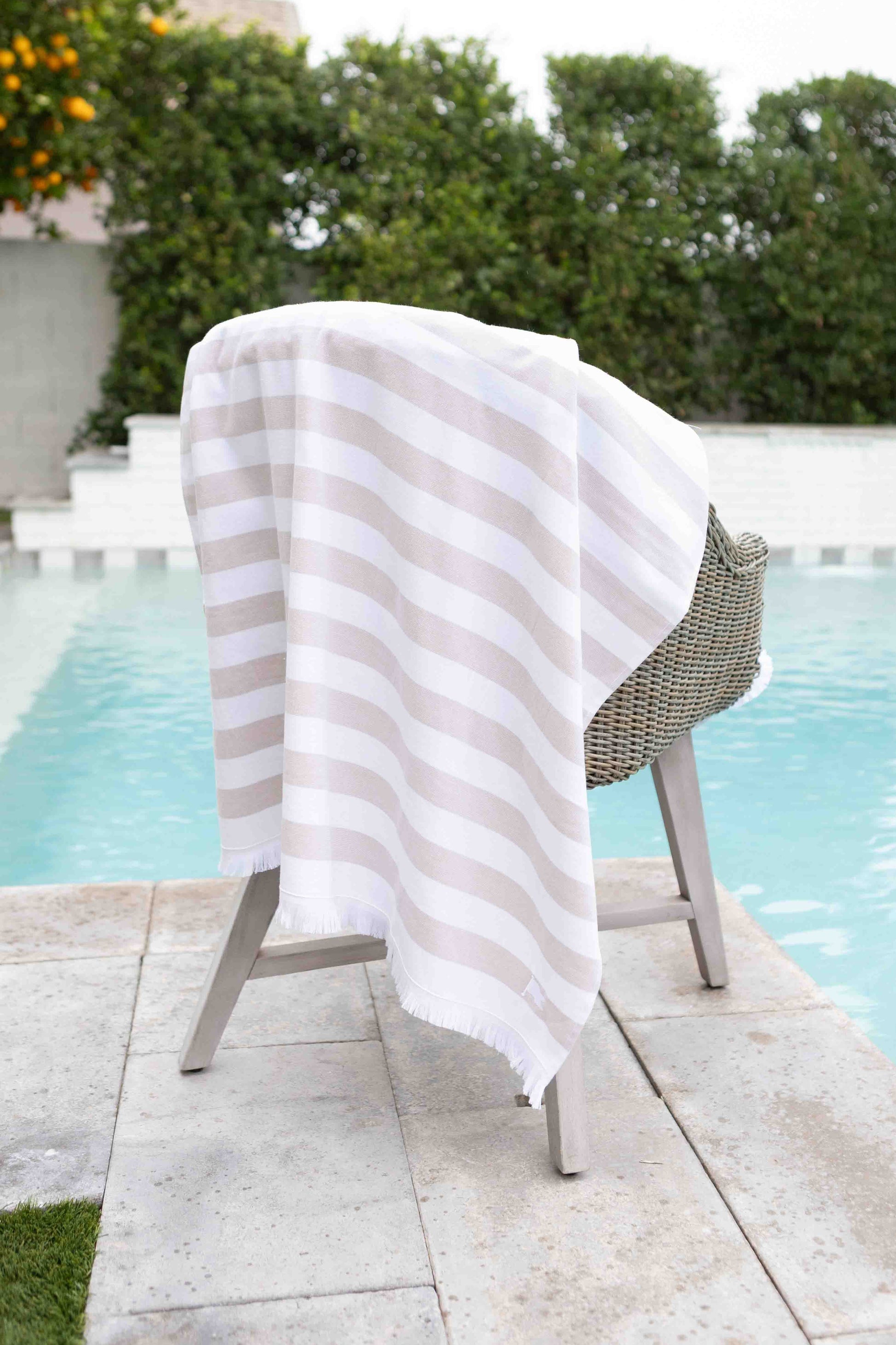White and tan striped luxury cotton Turkish towel at home pool
